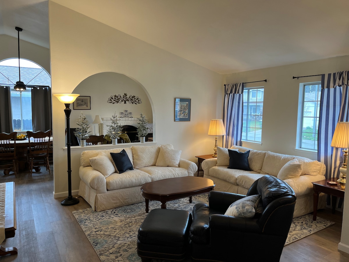 Living room with two sofas, leather chair, and arched pass-through